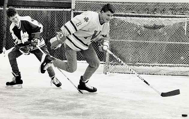 Eric and brother Brett play shinny in their backyard.